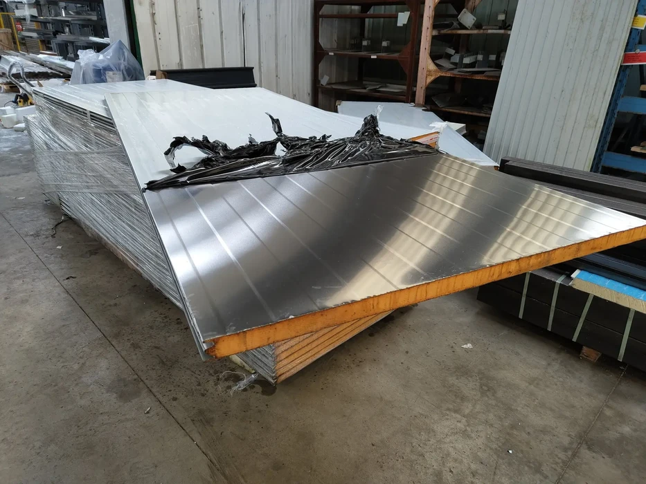 Entrepôt industriel avec panneaux sandwich isolants empilés sur supports métalliques