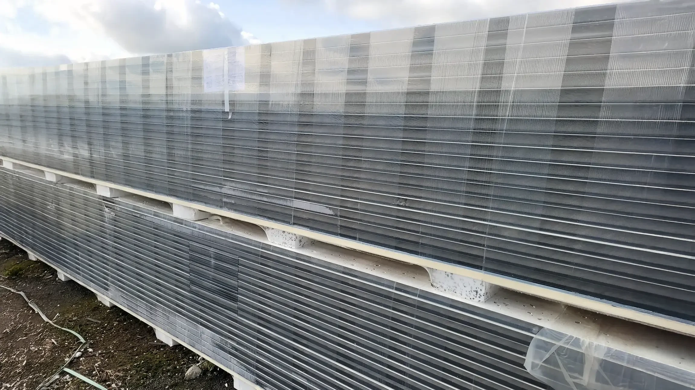 Stockage extérieur industriel de matériaux de construction avec rangées organisées de palettes chargées de parpaings et blocs de béton empilés sur site de production ou dépôt