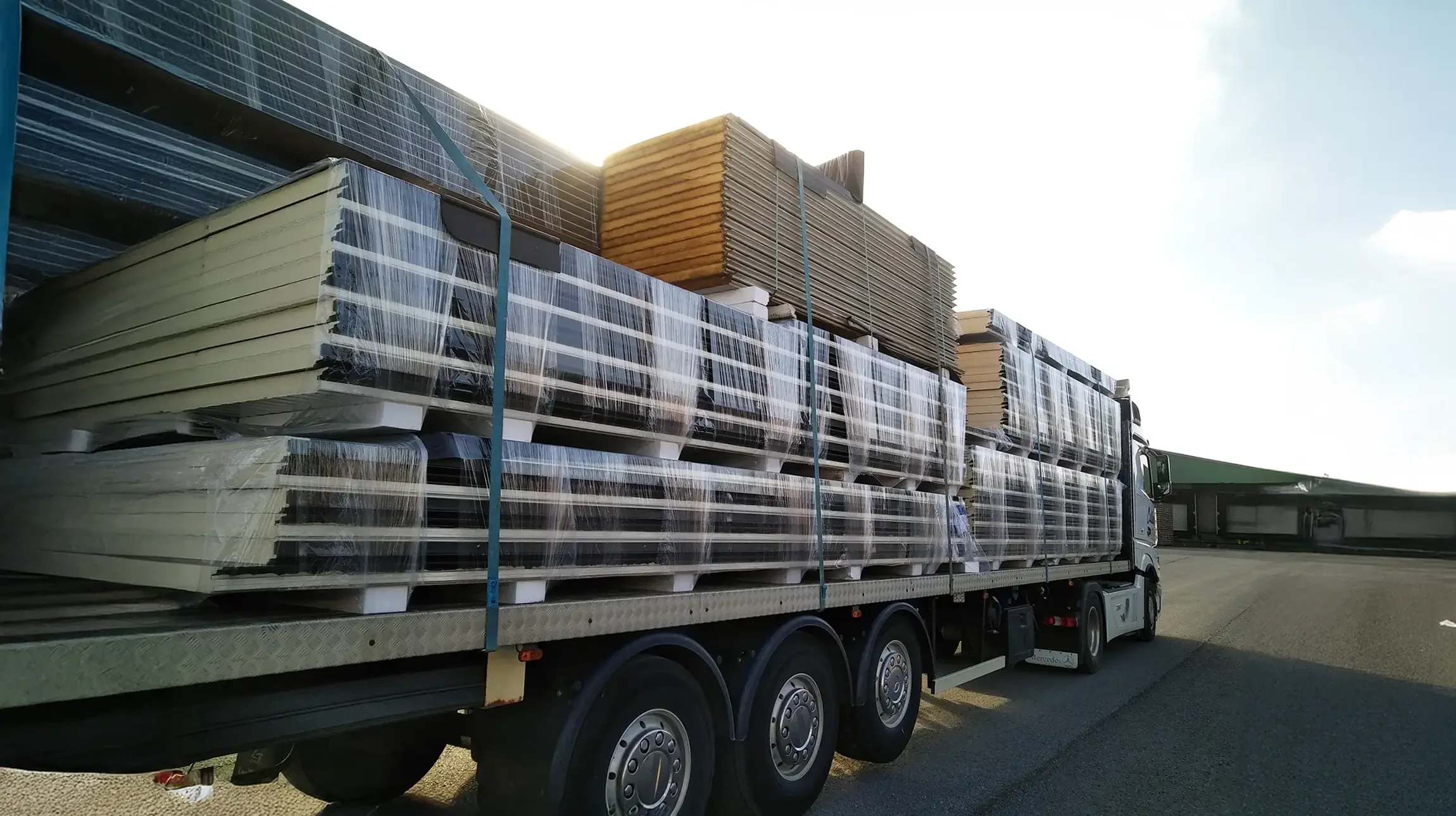Camion de déménagement blanc stationné devant immeuble résidentiel moderne en briques