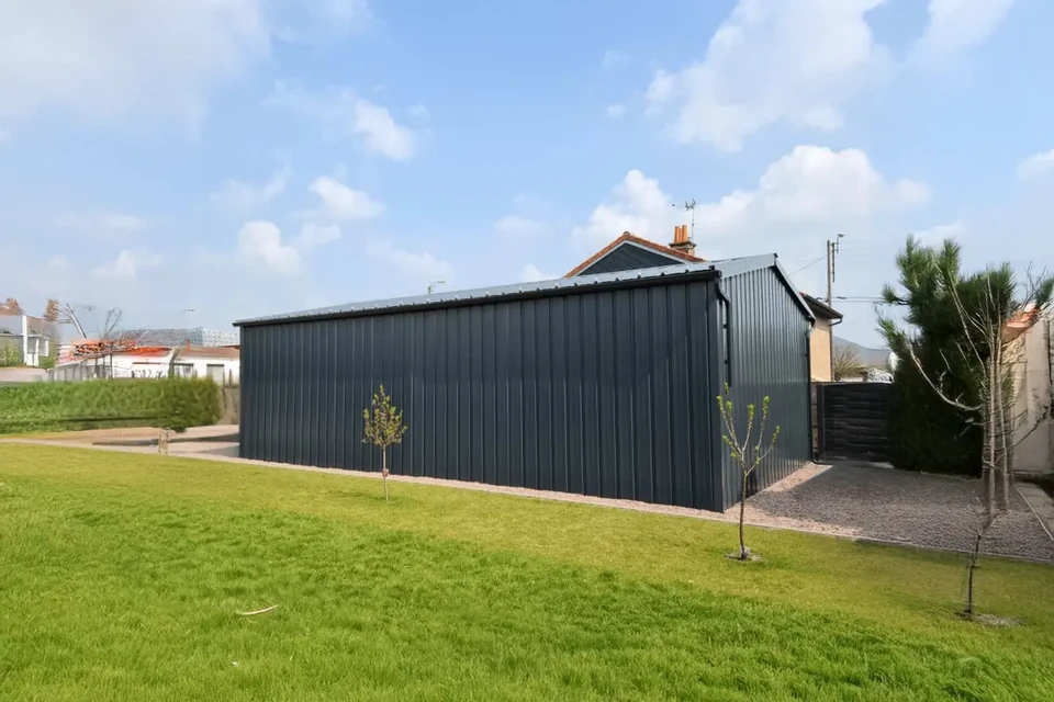 Intérieur d'usine sidérurgique avec barres d'acier incandescentes en cours de laminage