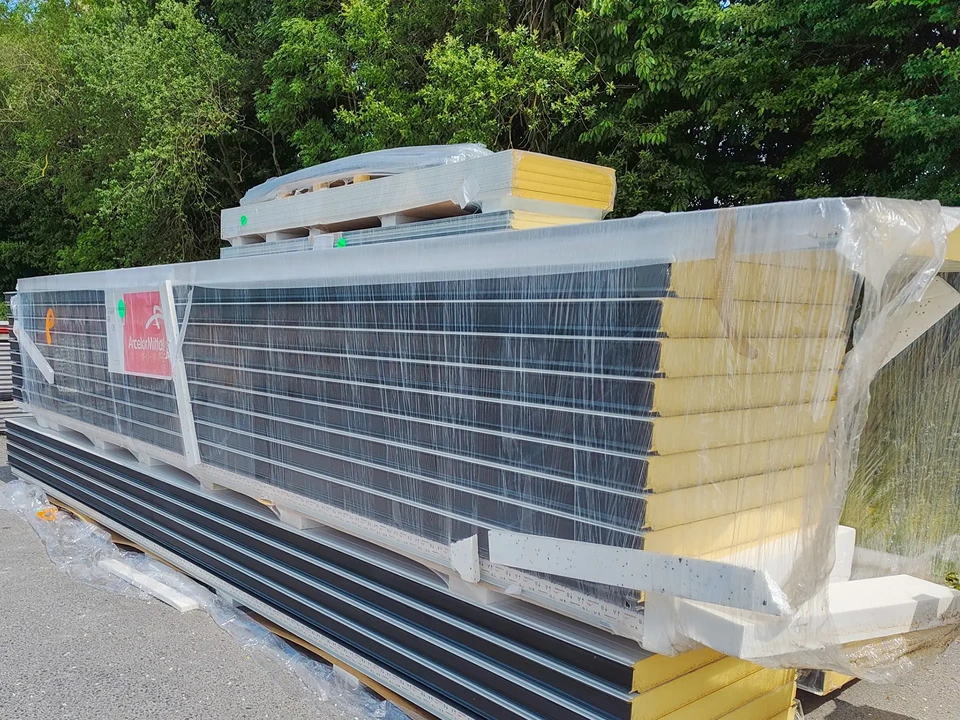 Femme aux cheveux roux tenant une tablette num&eacute;rique dans un supermarch&eacute;, examinant les rayons de l&eacute;gumes frais