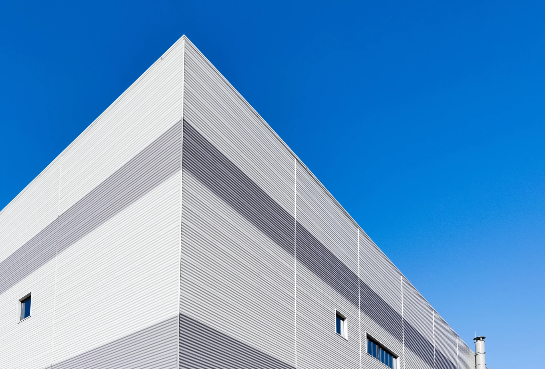 Façade extérieure d'un bâtiment industriel ou commercial moderne avec murs en béton préfabriqué gris clair